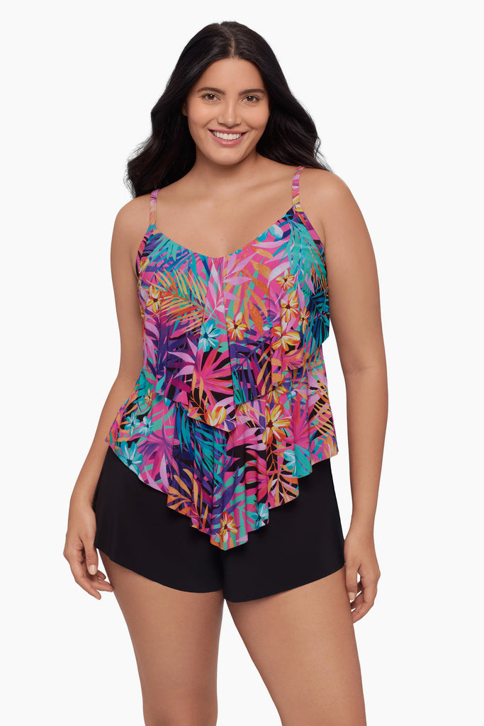 Woman wearing a tiered tankini top with a neon palm leaf print