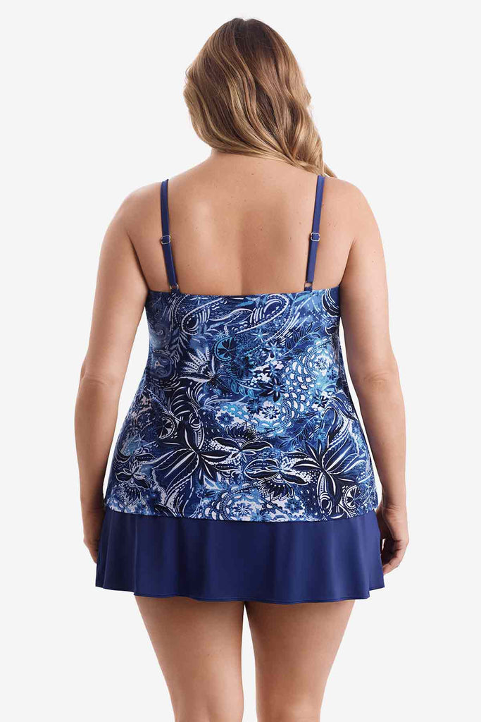 Woman turned away wearing a tiered one-piece swimsuit with an abstract blue pattern