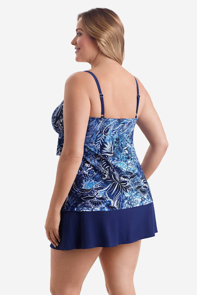 Woman turned left wearing a tiered one-piece swimsuit with an abstract blue pattern
