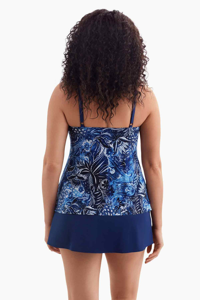 Woman turned away wearing a one-piece swimsuit with a blue abstract floral print