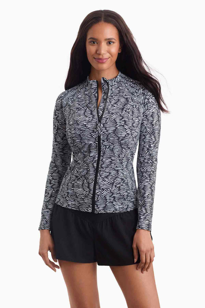 Woman wearing a black and white printed sun shirt with a zipper in the front